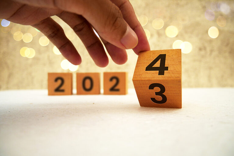 hand flipping block 2023 to 2024 text on table. Resolution, time